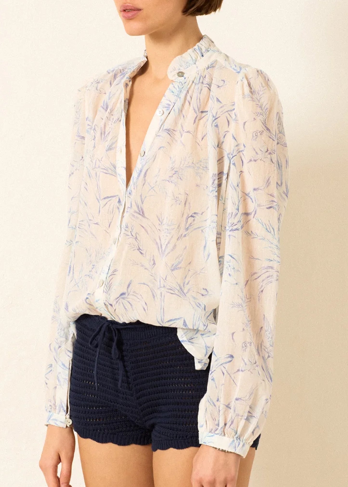 a sheer, long-sleeve button-up blouse by Alix Of Bohemia with a delicate blue and beige floral pattern