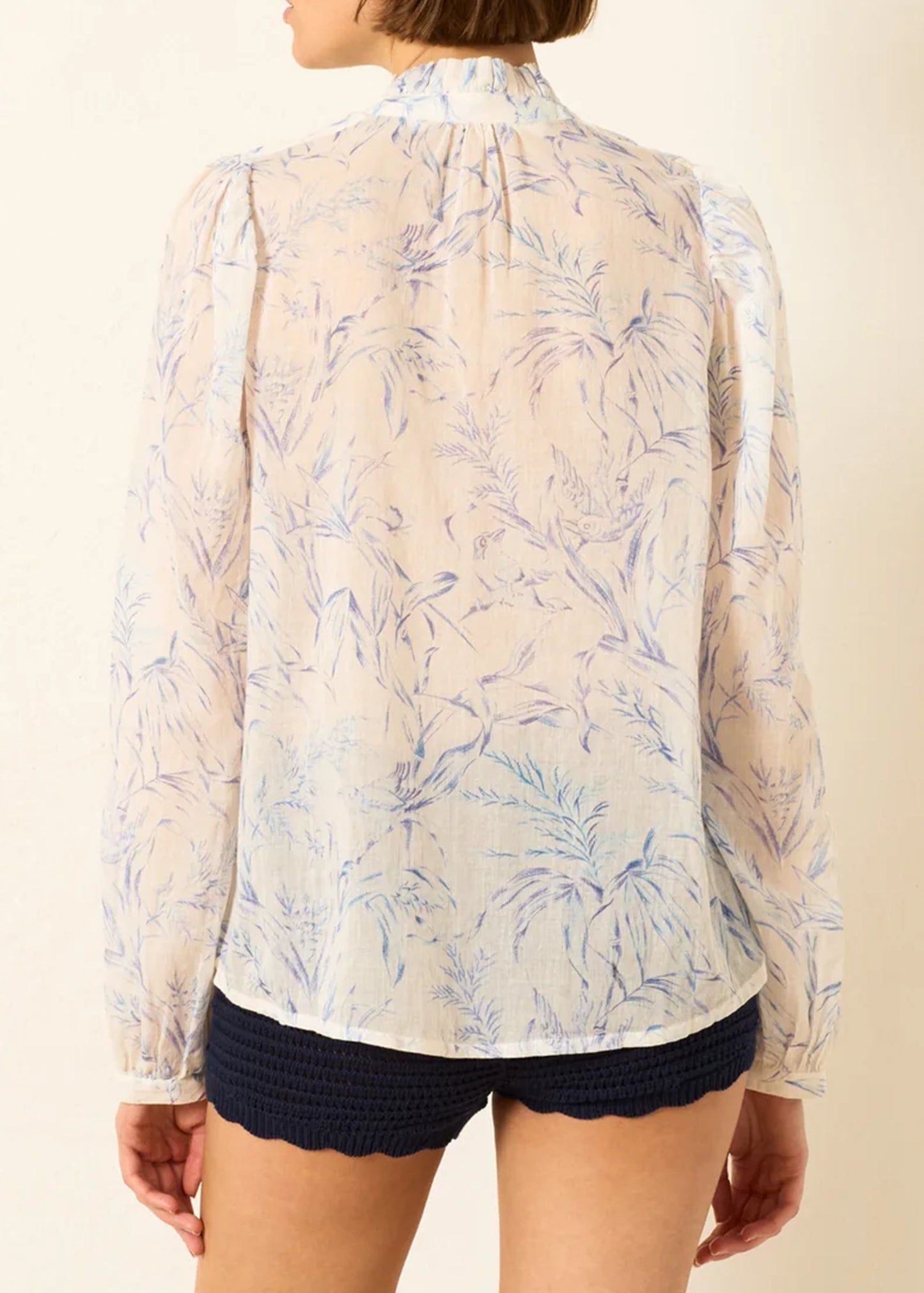 a sheer, long-sleeve button-up blouse by Alix Of Bohemia with a delicate blue and beige floral pattern