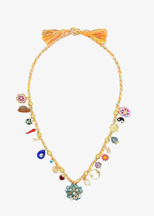 eaded necklace by Monoki with a braided tassel at the top and multiple colorful charm beads, including floral, and geometric