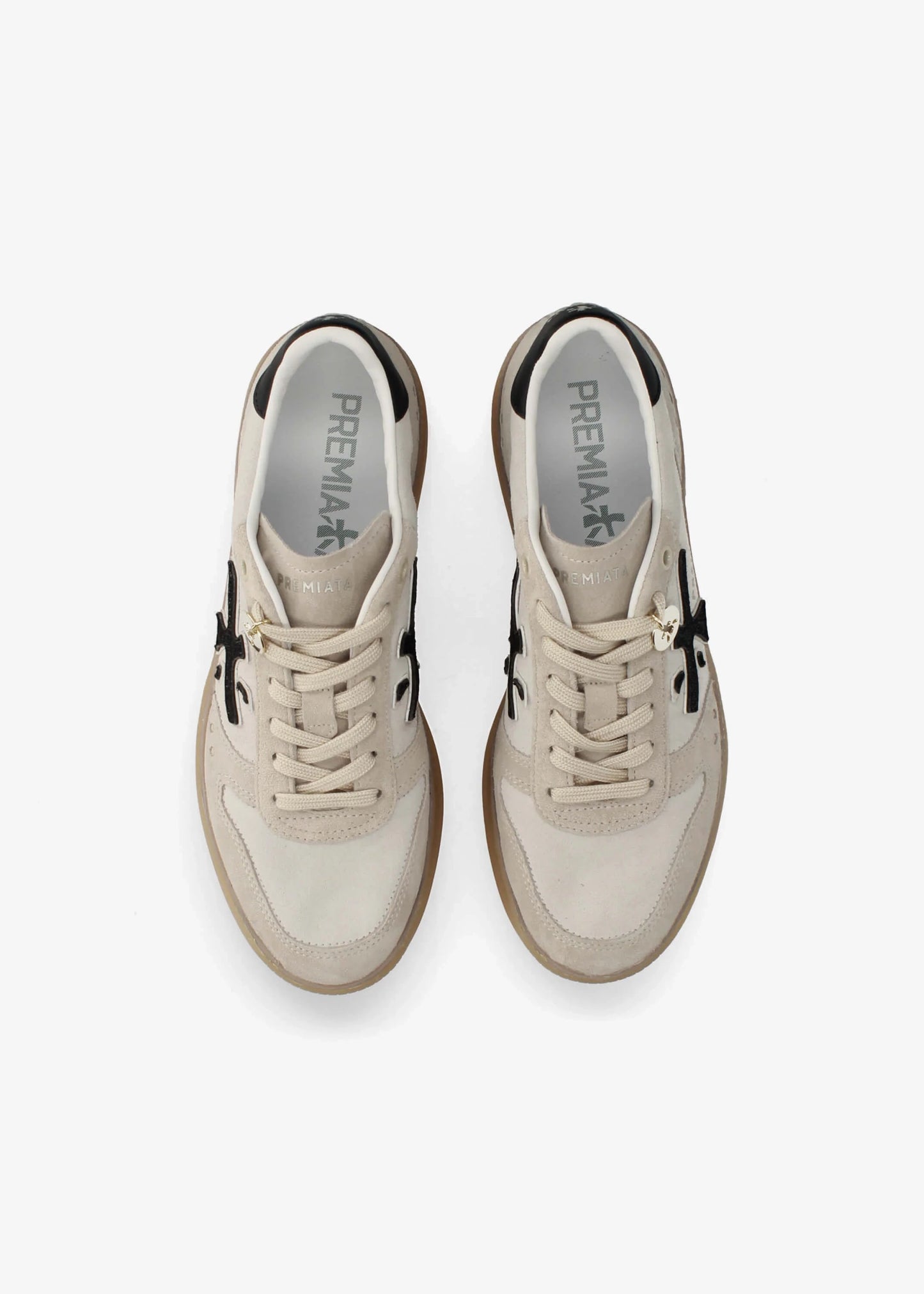 A low-top platform sneaker by Premiata, featuring a cream and beige suede and mesh upper, a black cross logo on the side, gold-tone hardware, and a thick tan gum sole.
