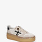 A low-top platform sneaker by Premiata, featuring a cream and beige suede and mesh upper, a black cross logo on the side, gold-tone hardware, and a thick tan gum sole.